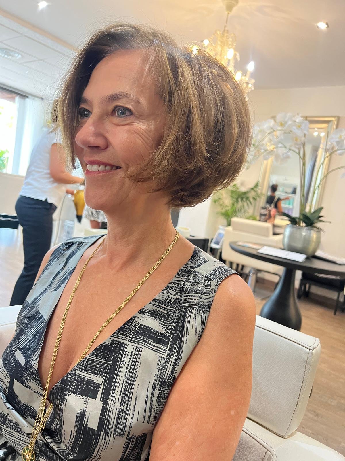 Cliente sonriendo tras su peinado en el salón